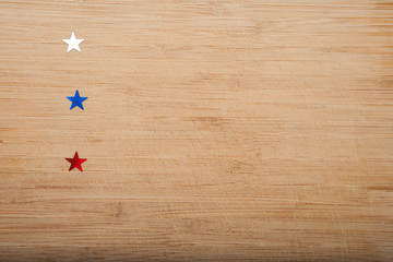 Confetti stars on wooden background. 4th July, Independence day, card, invitation in usa flag colors. View from Top , empty space.