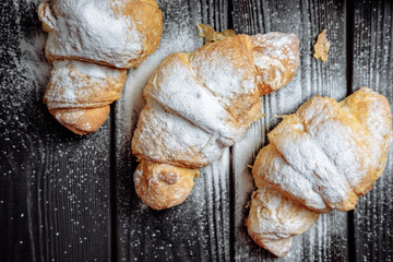  croissants on dark wooden background close-up top view