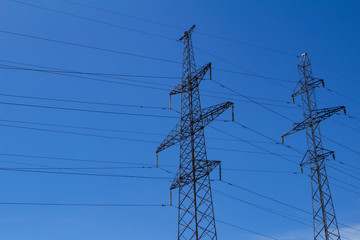 Electric high voltage tower with electric line against clouds blue sky