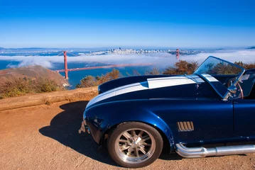 Poster Vingtage klassieke sportwagen met San Francisco Golden Gate bridge op mistige achtergrondmening van Marin Headland © PixHound