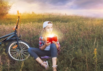 Child reading book or bible outdoors . Young Child's Hands Praying on Holy Bible .  Inner world of...