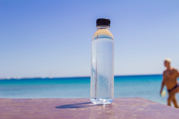 a bottle of water on a table on the beach on a sunny day as a symbol of proper nutrition