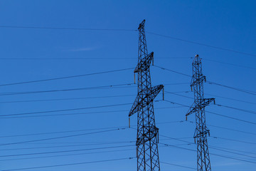 Electric high voltage tower with electric line against clouds blue sky