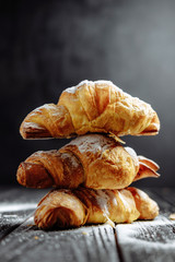 three croissants on dark wooden background close-up