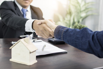 Successful agreement , estate,home buying contract concept, buyer shaking hand with bank employees after finishing signing contract in office