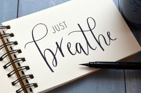 JUST BREATHE handwritten on notepad