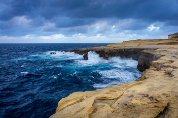 Fototapeta na wymiar Cliffs in Island of Gozo (Żebbug) view on Reqqa Point and Salt Pans. Windy day, winter, Malta.