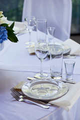Classic table setting.Appliances, glasses, white tablecloth and plate
