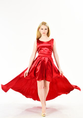 Dress rent service, fashion industry. Woman wears elegant evening red dress, white background. Girl blonde posing in dress. Lady rented fashionable dress for visiting event. Dress rent concept.