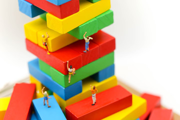 Miniature people : climbing colorful wooden block with challenging route on cliff, Concept of the path to purpose and success.