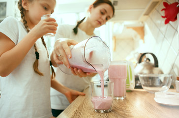 The happy smiling caucasian family in the kitchen preparing breakfast