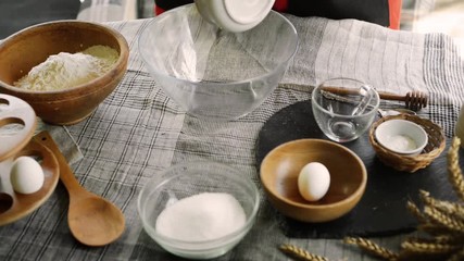 Woman put butter and sugar to glass bowl for dough tartles