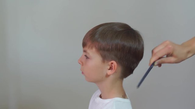 Self-isolation, quarantine of viral infection COVID 19. Healthy lifestyle. The boy's head is combed for 7 years with a comb.