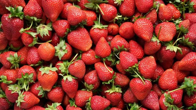 Background top view 4k video of strawberries rotating