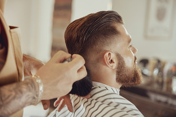 Barber secoue les cheveux du cou du client. Photo dans un style vintage