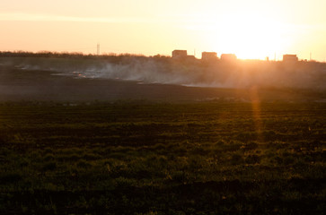 fields in the fire, grey smoke sunset light