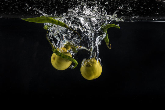 fresh green chillies and lemon splashing in water