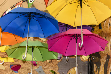 Fototapeta na wymiar Colourful umbrellas hang from a ceiling