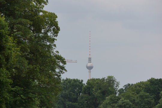Televison tower at the Alexanderplatz with crane arm from the left side, seen from the Hasenheide park, Neukoelln, Berlin
