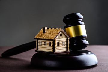 Concept of realty and law. Little wooden house and judges gavel 