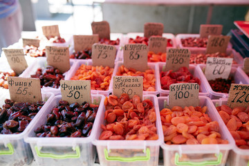 Different kinds of beans and dried fruits on sale at the local farmers summer market outdoors. Natural organic food on market place.