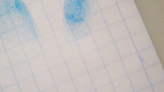 fingerprint on a sheet of paper is seen through a magnifying glass.close-up