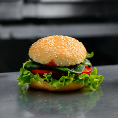 Close-up of tasty veggie quinoa chickpeas burger with tomotoes, 