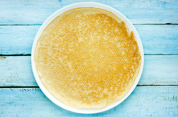 One empty round pancake on plate top view