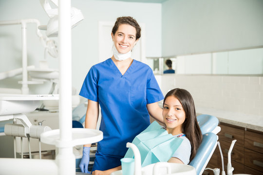 Portrait Of Smiling Dentist And Teenage Girl In Clinic