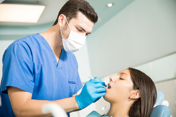 Fototapeta premium Dentist Analyzing Patient With Dental Equipment At Clinic