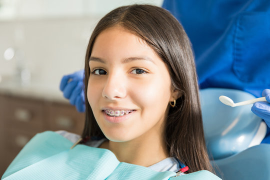 Portrait Of Smiling Teenage Girl With Braces In Clinic