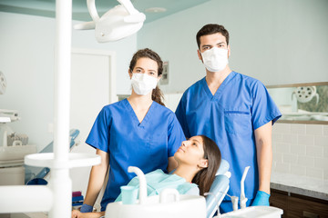 Portrait Of Dentists Standing By Patient At Clinic