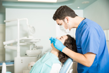 Side View Of Dentist Examining Patient In Dental Clinic