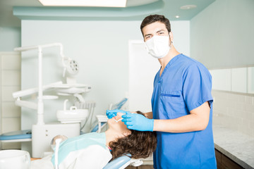 Portrait Of Confident Dentist With Patient In Dental Clinic