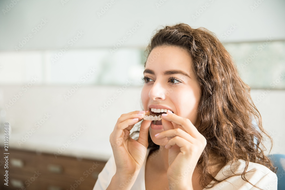 Wall mural woman wearing clear aligner in dental clinic