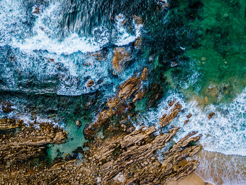 Aerial Drone View Of Dramatic Ocean Waves Crushing On Rocky Landscape © radub85