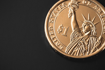 golden one dollar coin isolated on black background