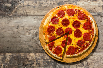 Hot italian pepperoni pizza on wooden table. Top view. Copyspace