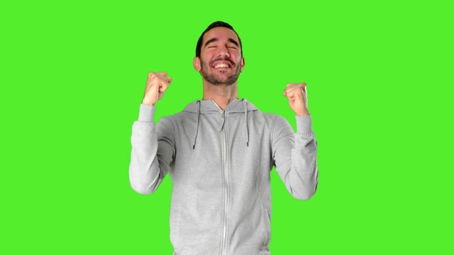 Happy young man on chroma key celebrating