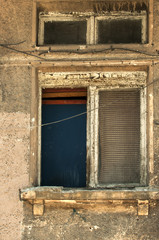 Grunge neglected window of old abandoned house closeup