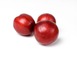 Fototapeta na wymiar Red plums on a white background isolated