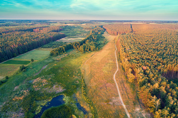Aerial view of countryside and river in the forest in evening. Sunset over the river
