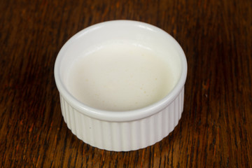 Cream-sour sauce over wooden