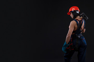 Sex equality and feminism. Back of sexy girl holding hammer. Woman working as mechanic.