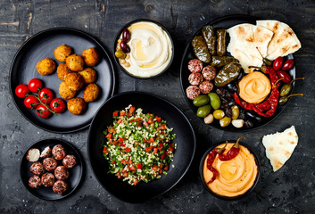 Arabic traditional cuisine. Middle Eastern meze platter with pita, olives, hummus, stuffed dolma,...