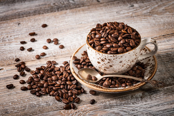 Coffee beans in cup on wooden table