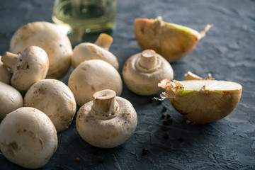 Fresh white Champions, spices and ingredients on the dark kitchen table. Concept of cooking mushroom dishes