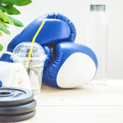 set for sports, towel, boxing gloves, dumbbell and a bottle of water on a light background. The concept of a healthy lifestyle. Close up