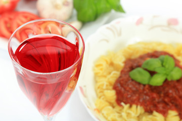 Lampka czerwonego wina i makaron spagetti z sosem neapolitańskim. - obrazy, fototapety, plakaty