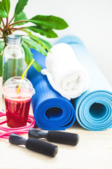 set for sports, a yoga mat, a towel, smoothies, jumping rope, a bottle of water. The concept of a healthy lifestyle Closeup
